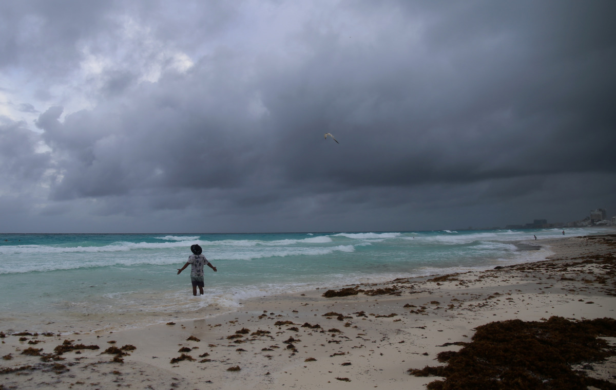 A tourist stands on a beach as Hurricane Grace approaches, in Cancun, Mexico, August 18, 2021. REUTERS/Paola Chiomante NO RESALES. NO ARCHIVES
