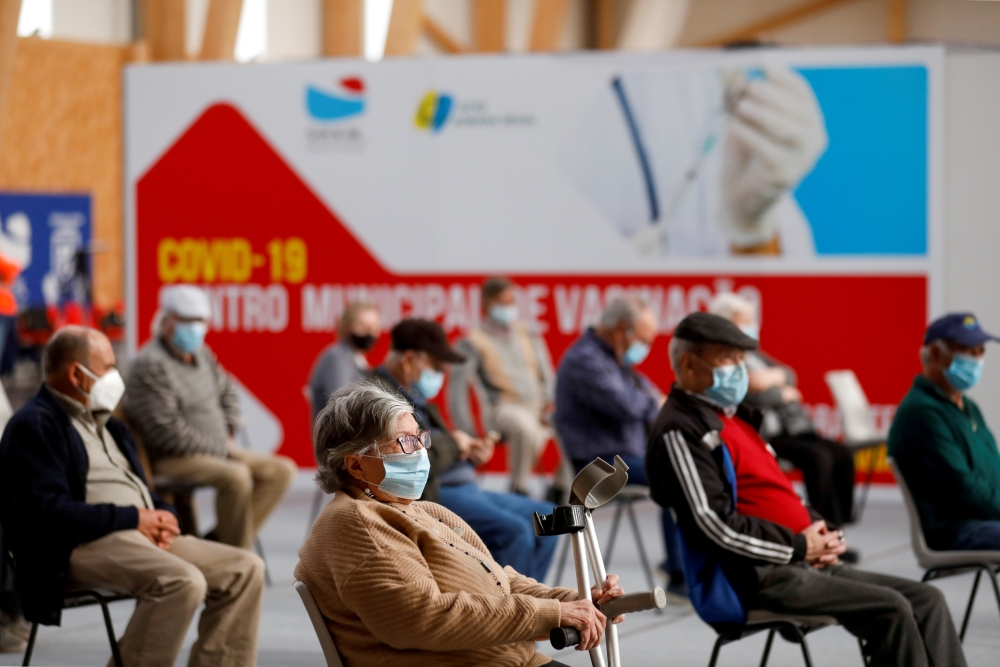 People wait in a COVID-19 vaccination centre, as Portugal resumes vaccination with AstraZeneca shots after a temporary suspension, amid the coronavirus disease (COVID-19) pandemic, in Seixal, Portugal, March 22, 2021. REUTERS/Pedro Nunes//File Photo