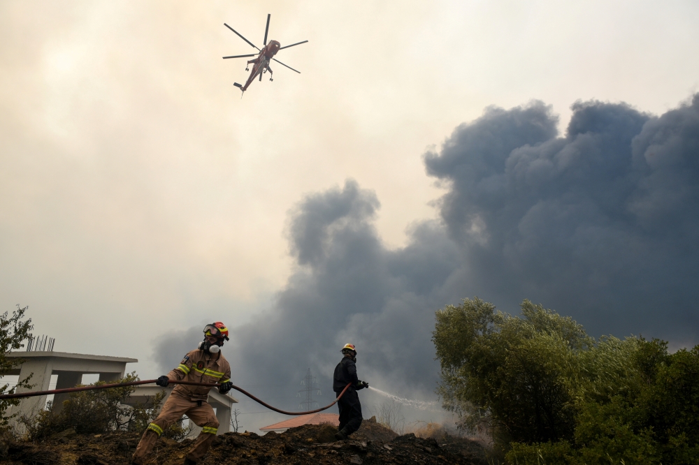 Firefighters try to extinguish fires as a wildfire continues to rage near the village of Afidnes, north of Athens, Greece, August 6, 2021. REUTERS/Alexandros Avramidis/File Photo
