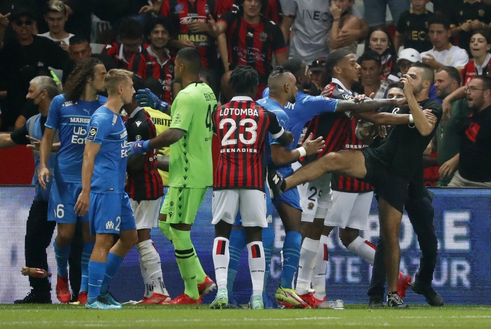 Pitch invaders clash with players as the game is interrupted REUTERS/Eric Gaillard