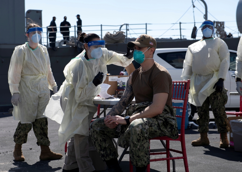 FILE PHOTO: A United States Navy officer from the amphibious ship USS San Diego (LPD 22) receives a vaccine against Coronavirus. this picture taken February 26, 2021 and released by U.S Navy on February 27, 2021. Brandon Woods/U.S. Navy/Handout via REUTER