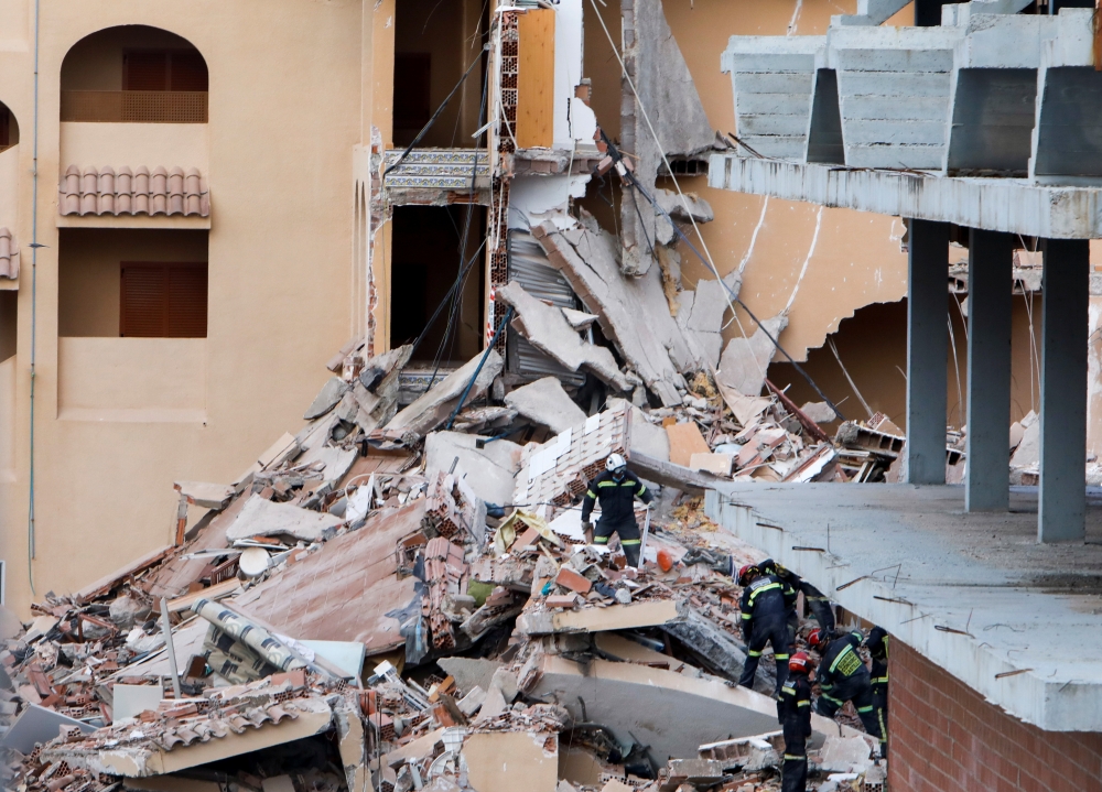 Firefighters work among the debris of a collapsed building in the town of Peniscola, Spain, August 26, 2021. REUTERS/Eva Manez NO RESALES. NO ARCHIVES