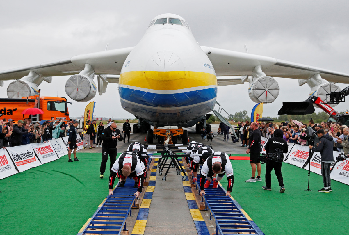 Ukrainian strongman athletes attempt to set a world record for pulling the world's largest cargo plane Antonov An-225 Mriya at an airfield in the settlement of Hostomel outside Kyiv, Ukraine August 26, 2021. REUTERS/Gleb Garanich
