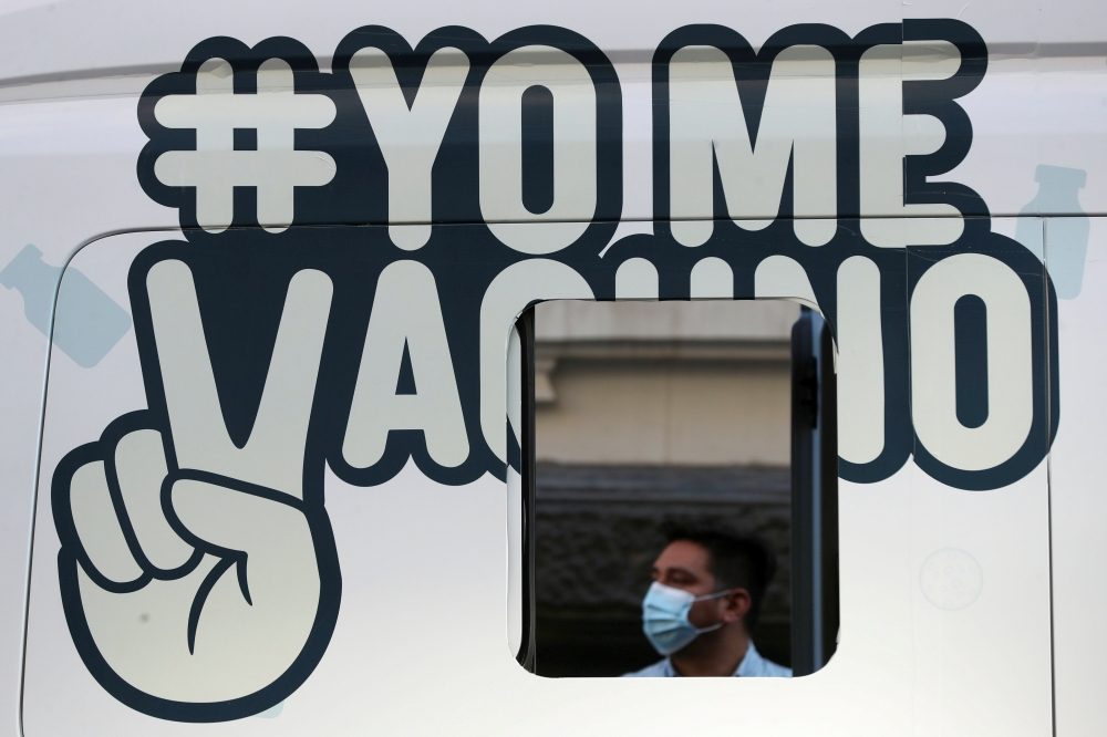 FILE PHOTO: A man waits outside a mobile vaccination centre to receive a dose of Sinovac's CoronaVac coronavirus disease (COVID-19) vaccine in Santiago, Chile May 24, 2021. The sign reads ''I get vaccinated