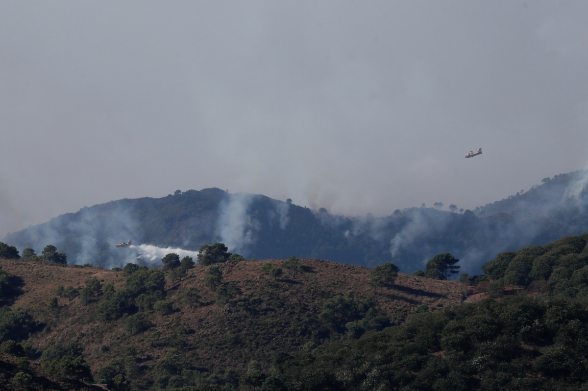 Firefighting planes are seen flying from Parauta as they make a water drop over a wildfire on Sierra Bermeja mountain, in Estepona, Spain, September 10, 2021. REUTERS/Jon Nazca
