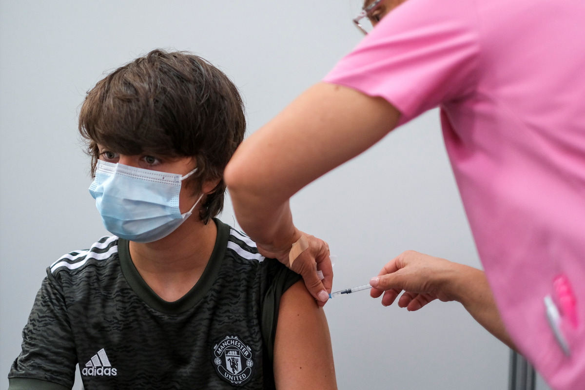 A boy receives his second dose of the Pfizer coronavirus disease (COVID-19) vaccine at a vaccination centre in Seixal, Portugal, September 11, 2021. Picture taken September 11, 2021. REUTERS/Pedro Nunes
