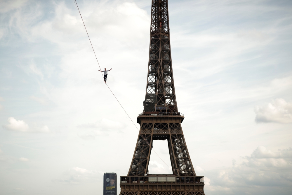 French acrobat Nathan Paulin walks on a slackline between the Eiffel Tower and the Theatre National de Chaillot as part of events around France for National Heritage Day in Paris, France, September 18, 2021. Reuters/Benoit Tessier