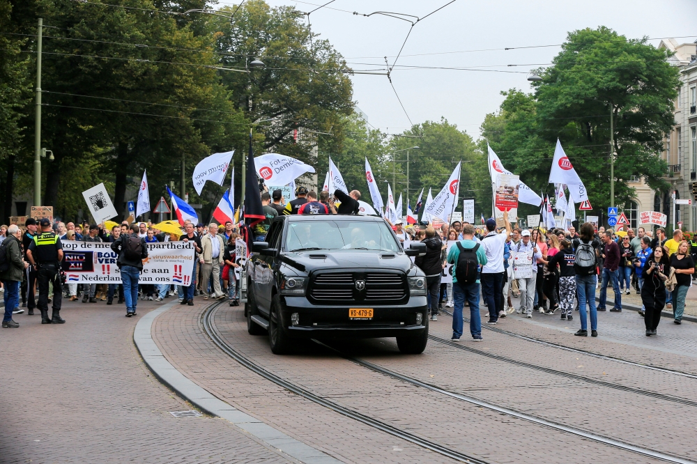 People take part in a protest on the day the Dutch authorities introduce a mandatory 