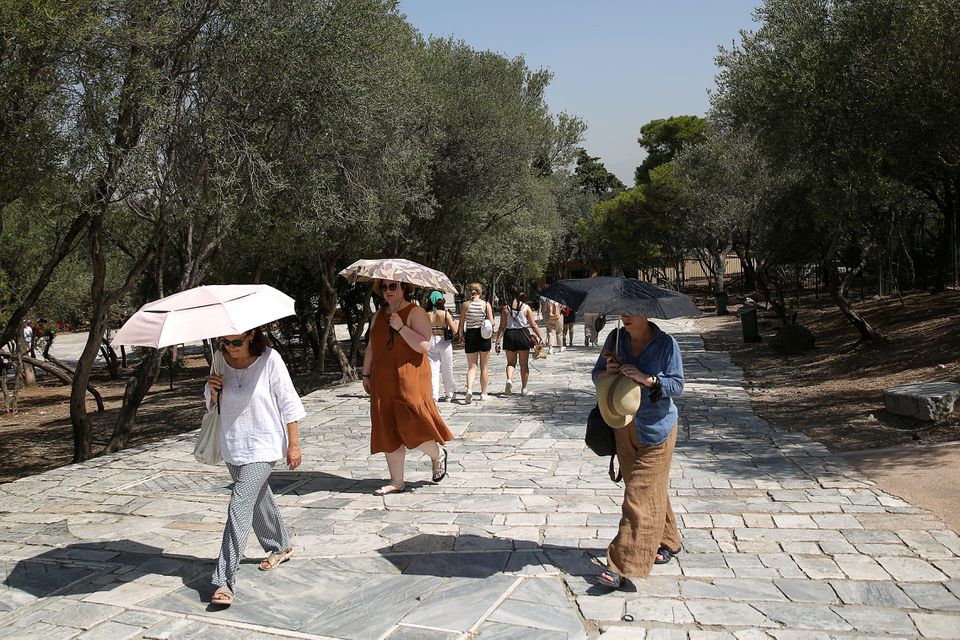 People without protective face masks make their way at an archaeological site of the Acropolis following the easing of measures against the spread of the coronavirus disease (COVID-19) in Athens, Greece, June 24, 2021. REUTERS/Costas Baltas

