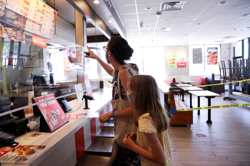Naomi and Lydia Hassebroek order food from Taco Bell during the outbreak of the coronavirus disease (COVID-19) in Brooklyn, New York, U.S., June 23, 2020. REUTERS/Caitlin Ochs/File Photo