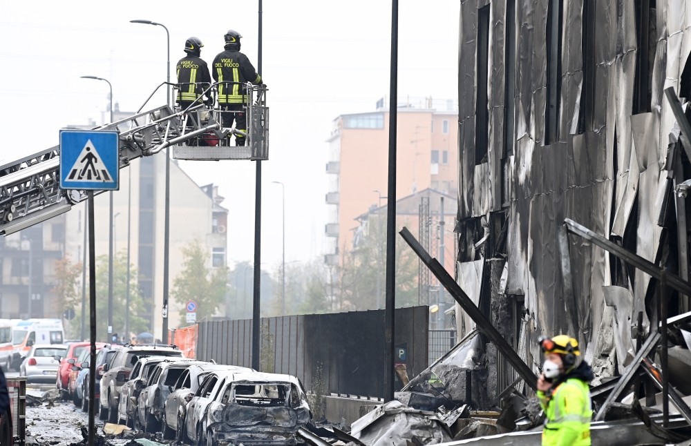 Fire fighters work at the scene where a small plane crashed into a building in San Donato Milanese, Italy, October 3, 2021. REUTERS/Flavio Lo Scalzo
