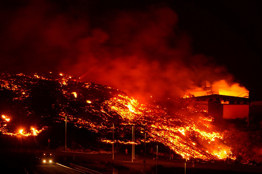 Lava burns buildings following the eruption of the Cumbre Vieja volcano in Tacande, Spain, October 9, 2021. Reuters/Juan Medina