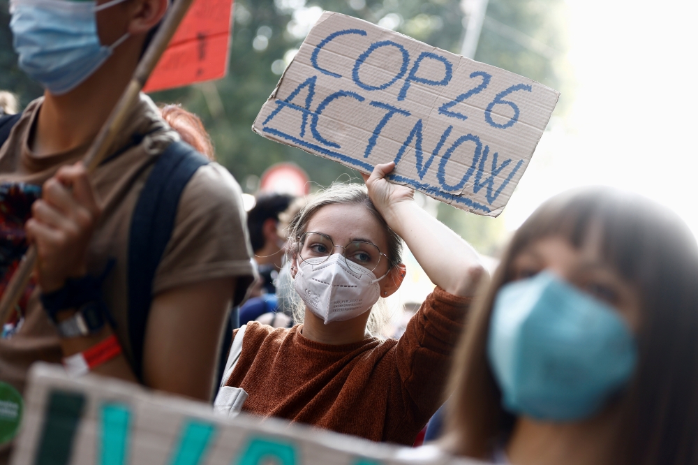 People take part in the 'Global march for climate justice' while environment ministers meet ahead of Glasgow's COP26 meeting, in Milan, Italy, October 2, 2021. Reuters/Guglielmo Mangiapane/File Photo