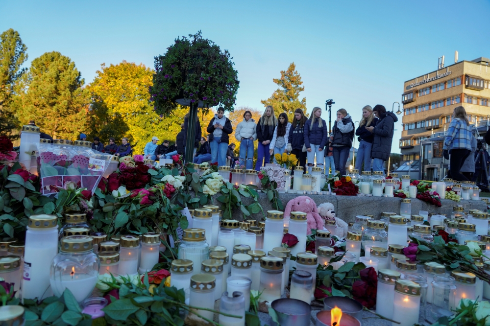 People lay down flowers and light candles to honour the dead, after a man killed five people in the city on Wednesday night, at Stortorvet in Kongsberg, Norway October 15, 2021. Terje Bendiksby/NTB/via REUTERS