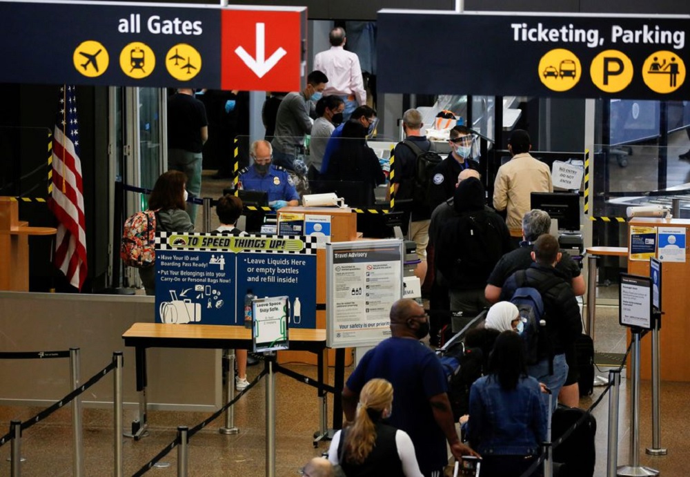 Travelers queue in a security line limited to every other lane for social distancing at Seattle-Tacoma International Airport in SeaTac, Washington, U.S. April 12, 2021. REUTERS/Lindsey Wasson