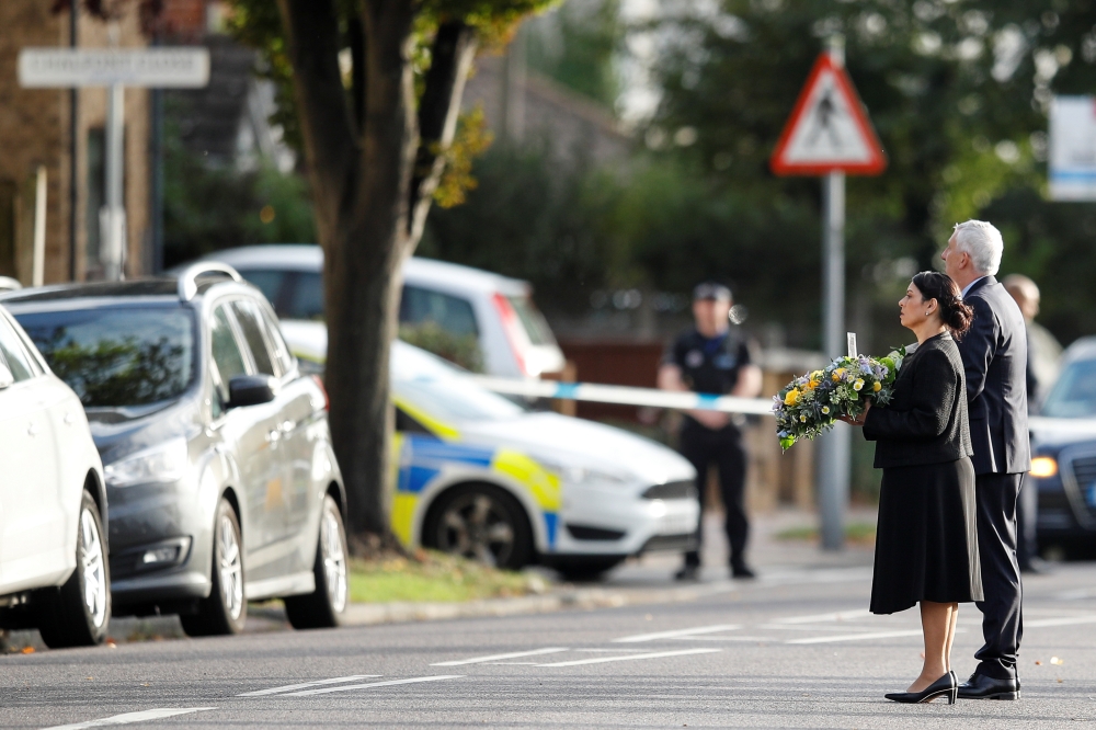 Britain's Home Secretary Priti Patel holds flowers as she arrives at the scene where British MP David Amess was stabbed to death, in Leigh-on-Sea, Britain, October 16, 2021. Reuters/Peter Nicholls