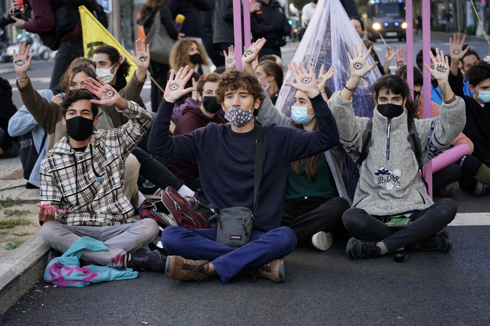 Climate activists sit on a road during a protest by Extinction Rebellion against the COP26 summit in Madrid, Spain, October 25, 2021. Reuters/Juan Medina