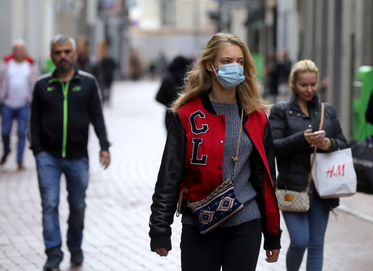 FILE PHOTO: People with and without protective masks walk on the street while shopping as the spread of coronavirus disease (COVID-19) continues in Amsterdam, Netherlands October 7, 2020. REUTERS/Eva Plevier/File Photo
