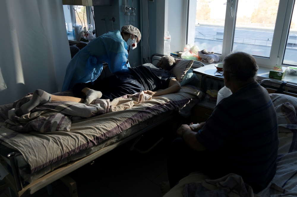 A medical specialist treats a patient suffering from the coronavirus disease (COVID-19) at the intensive care unit (ICU) of the City Clinical Hospital Number 3 in Kyiv, Ukraine October 26, 2021. REUTERS/Stanislav Kozliuk
