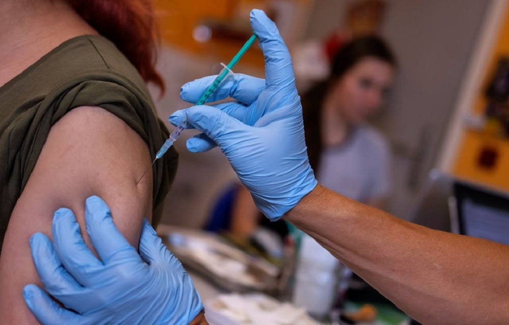 A doctor vaccinates a woman with a coronavirus disease (COVID-19) vaccine, in his doctor's office in Berlin, Germany, November 2, 2021. REUTERS/Hannibal Hanschke