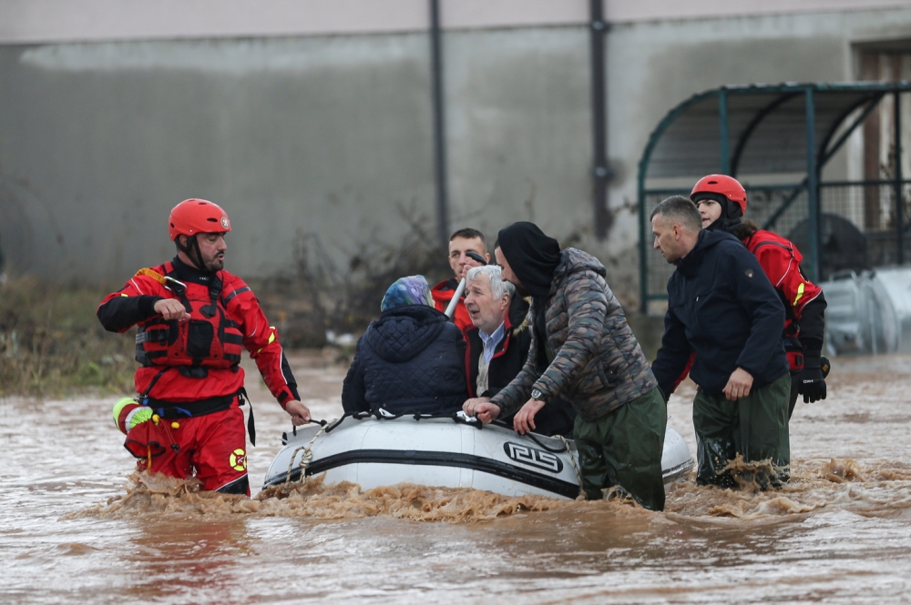 Rescue workers speak with people on a flooded street in Otes near Sarajevo, Bosnia and Herzegovina November 5, 2021. REUTERS/Dado Ruvic