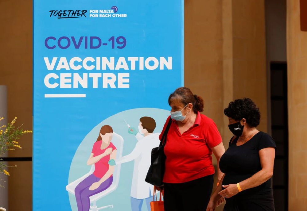 People walk outside a vaccination centre at the University of Malta, after authorities announced that Malta had achieved herd immunity with 70% of the population being receiving at least one vaccine dose against the coronavirus disease (COVID-19), in Msida, Malta May 24, 2021. REUTERS/Darrin