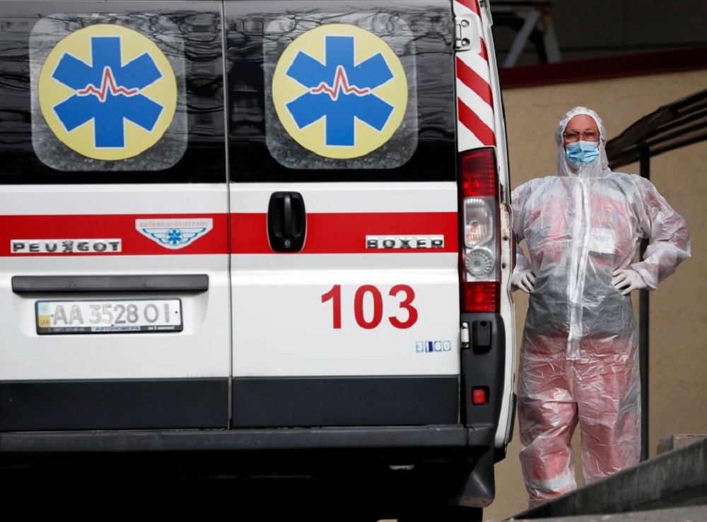 A health worker stands near an ambulance carrying a COVID-19 patient, as they wait in the queue at a hospital for people infected with the coronavirus disease in Kyiv, Ukraine October 18, 2021. REUTERS/Gleb Garanich

