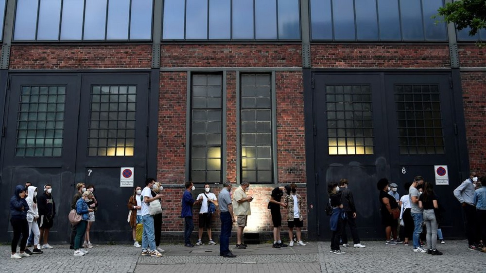 People queue to receive a vaccine against the coronavirus disease (COVID-19), during a night of vaccinations with music, at the Arena Treptow vaccination centre in Berlin, Germany, August 9, 2021. John Macdougall/Pool via REUTERS
