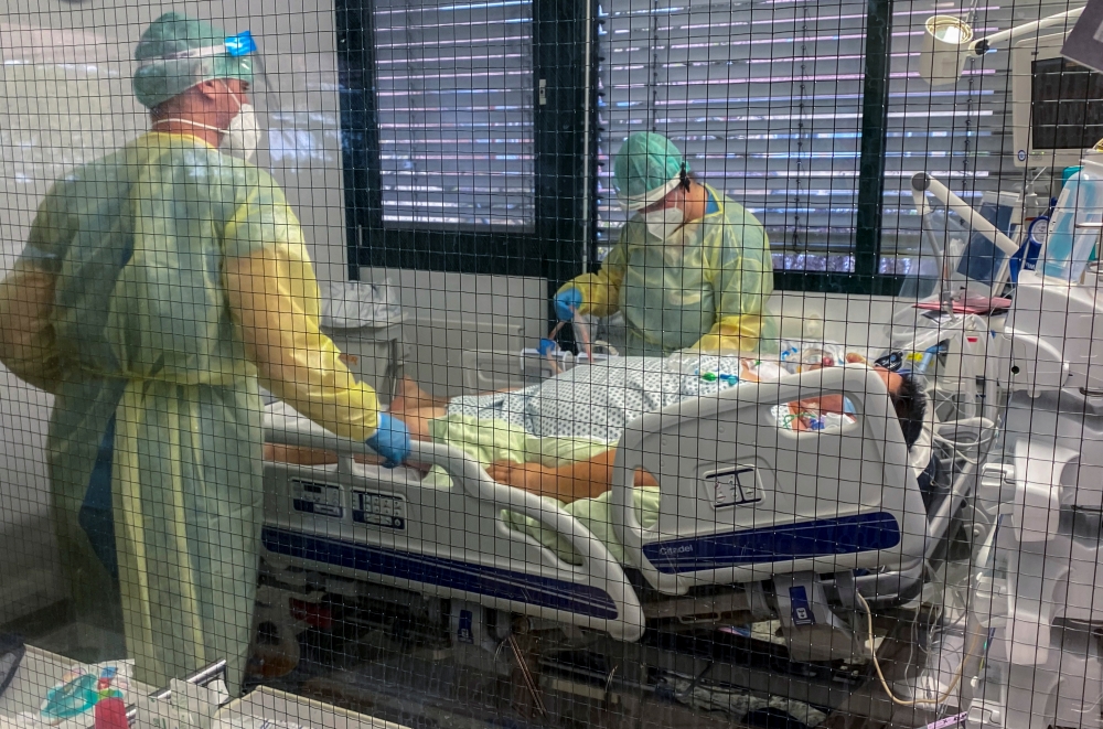 Medical staff members of Munchen Klinik Schwabing hospital take care of a patient infected with the coronavirus disease (COVID-19) in the intensive care unit in Munich, Germany, November 12, 2021. REUTERS/Ayhan Uyanik