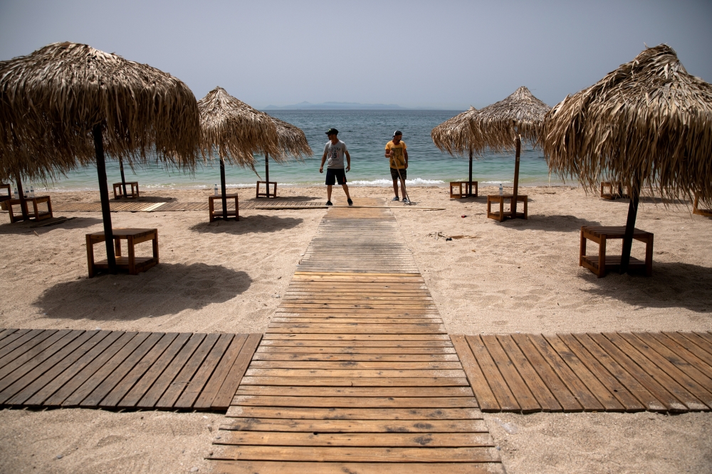Workers install wooden corridors on a beach, a day before the official opening of beaches to the public following the easing of measures against the spread of the coronavirus disease (COVID-19), in Athens, Greece, May 15, 2020. REUTERS/Alkis Konstantinidis/File Photo