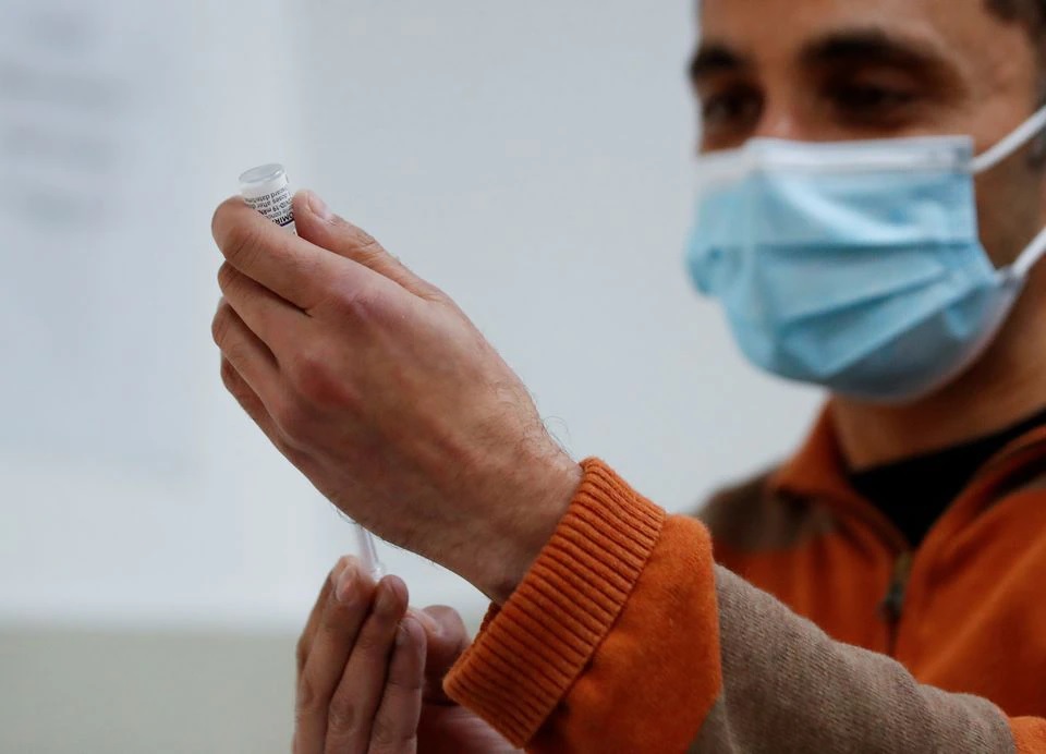 A pharmacist prepares a COVID-19 vaccine in Northampton, Britain, October 21, 2021. REUTERS/Andrew Boyers


