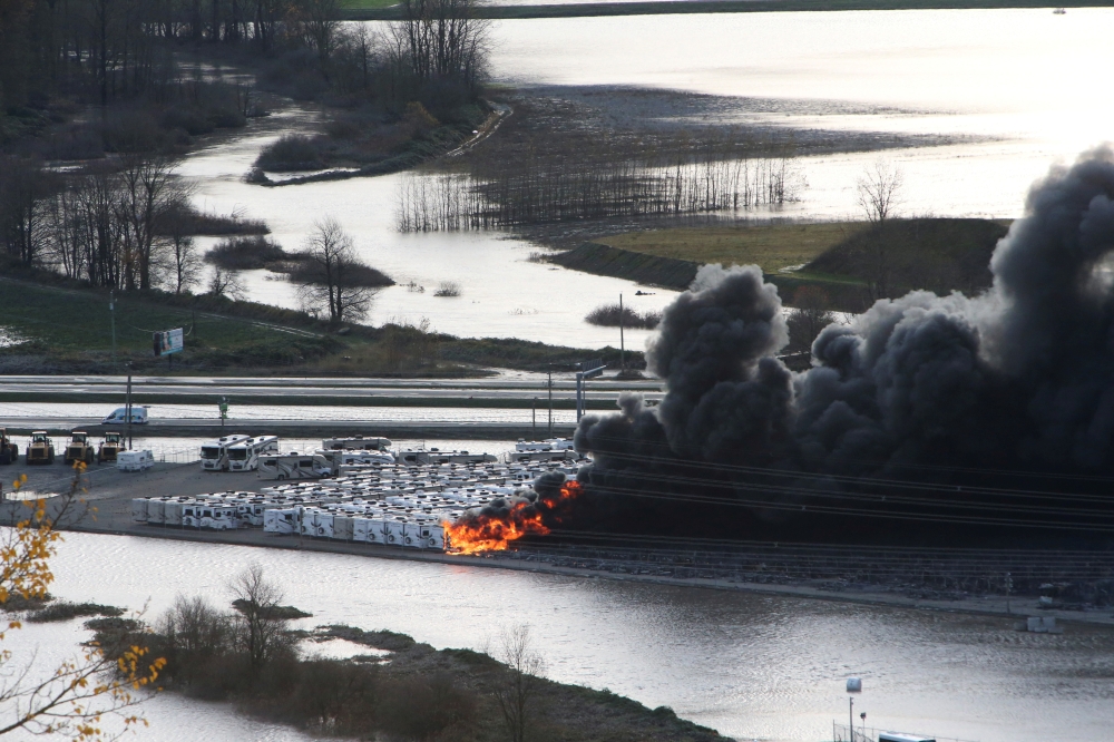 RV trailers burn in a storage yard after rainstorms caused widespread flooding and landslides in Abbotsford, British Columbia, Canada, November 17, 2021. Reuters/Jesse Winter