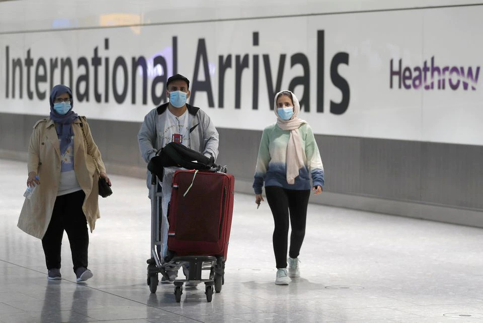 Passengers walk through the International arrivals area of Terminal 5 in London's Heathrow Airport, Britain, August 2, 2021. REUTERS/Peter Nicholls

