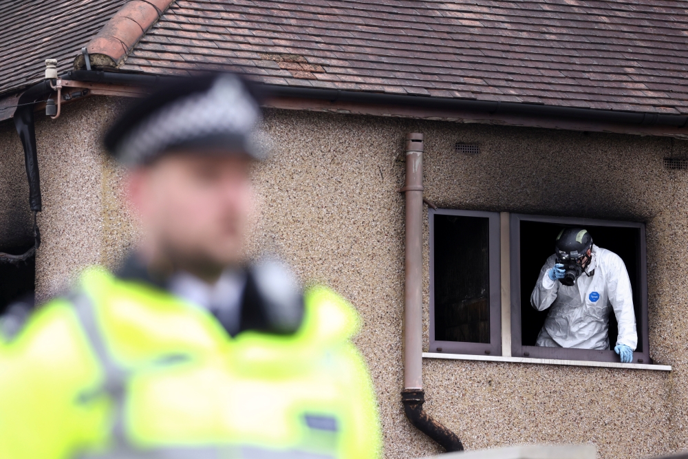 An investigator inspects the scene of a house fire in Bexleyheath, London, Britain November 19, 2021. REUTERS/Tom Nicholson