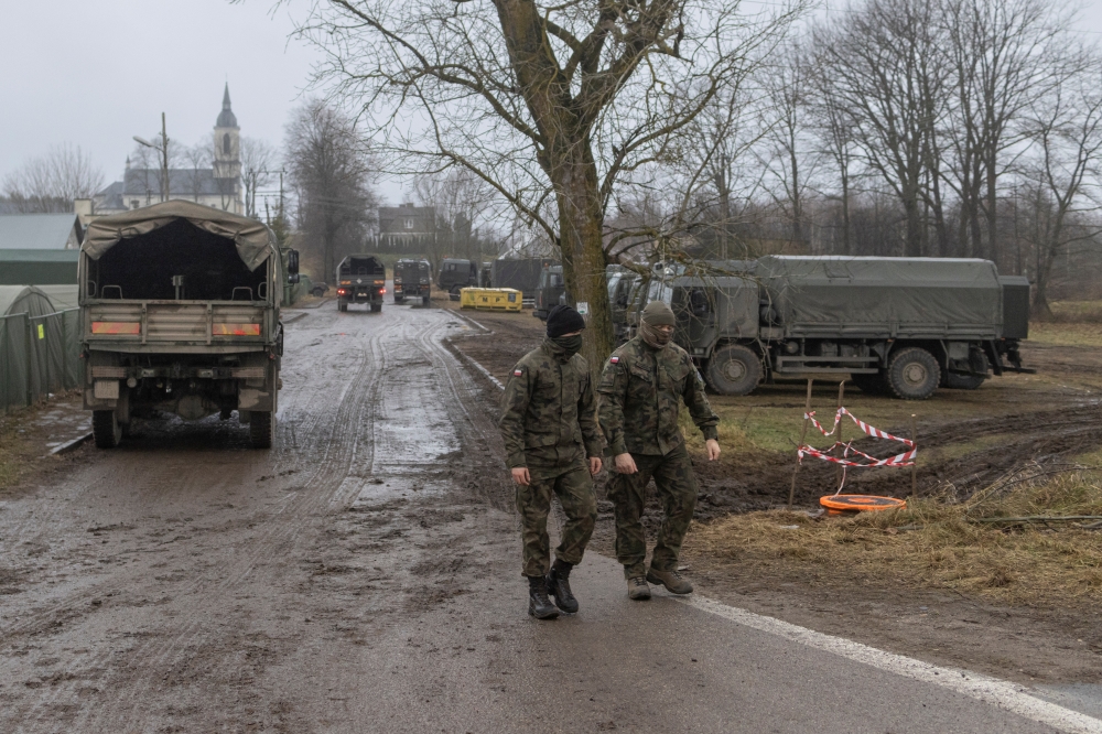 Soldiers from 16th Pomeranian Mechanised Division walk outside their temporary camp during the migrant crisis on the Belarusian-Polish border in the village of Szudzialowo near the town of Sokolka, Poland, November 19, 2021. Reuters/Marko Djurica
