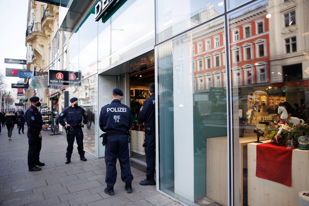 Police officers check the vaccination status of shoppers at the entrance of a store after the Austrian government imposed a lockdown on the roughly two million people who are not fully vaccinated against the coronavirus disease (COVID-19) in Vienna, Austria, November 16, 2021. Reuters/Lisi Niesner