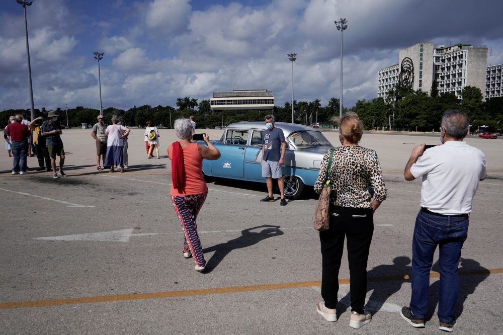 Tourists from Spain take pictures at the Revolution square in Havana, Cuba, November 23, 2021. Picture taken on November 23, 2021. REUTERS/Alexandre Meneghini