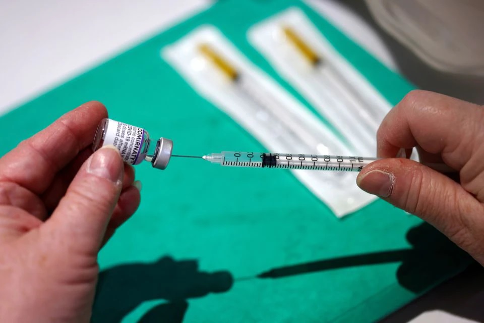 A medical worker prepares a dose of the 