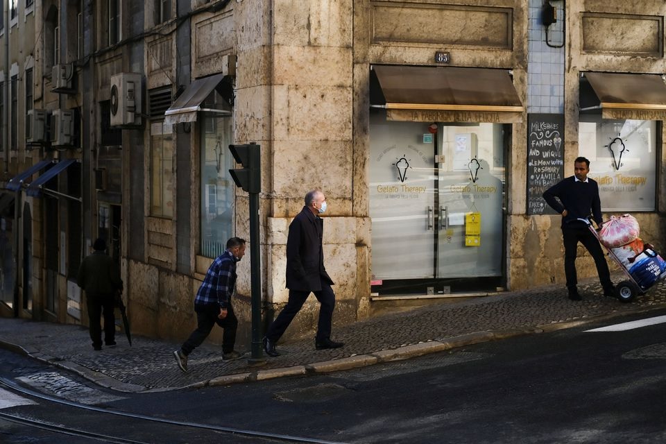 A man wearing a protective mask due to coronavirus disease (COVID-19) pandemic walks in central Lisbon, Portugal, November 25, 2021. REUTERS/Pedro Nunes
