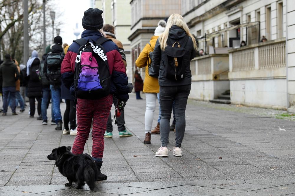 People queue for vaccination against COVID-19 outside a doctor's practice in Berlin, Germany, December 1, 2021. REUTERS/Annegret Hilse/File Photo