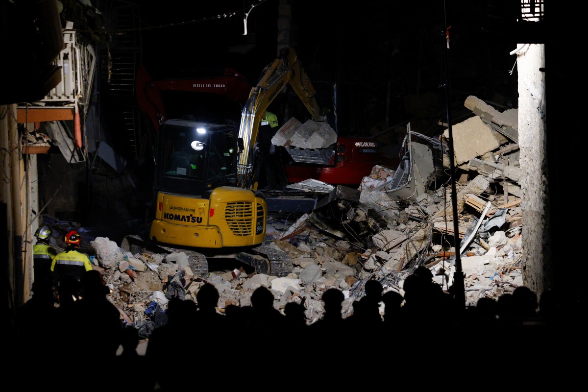 Members of a rescue team work at the scene of a gas explosion in a residential building, in Ravanusa, Italy, December 12, 2021. REUTERS/Guglielmo Mangiapane
