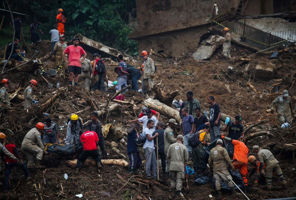 People carry bodies at a mudslide at Morro da Oficina after pouring rains in Petropolis, Brazil February 16, 2022. REUTERS/Ricardo Moraes