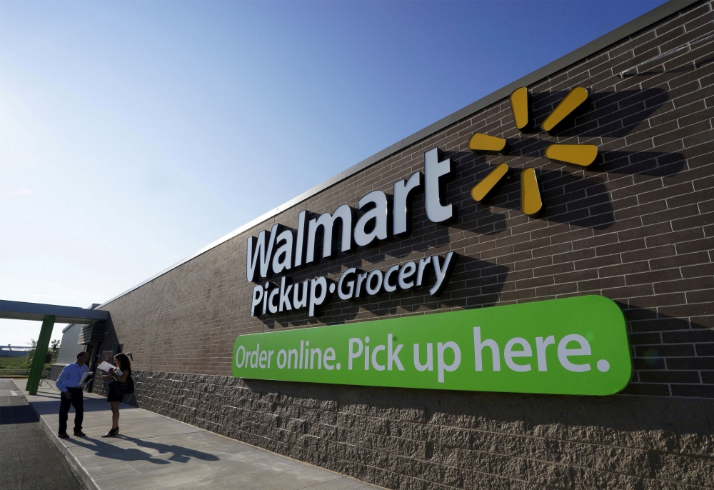 People talk outside a Walmart Pickup-Grocery test store in Bentonville, Arkansas, June 4, 2015. REUTERS/Rick Wilking/File Photo