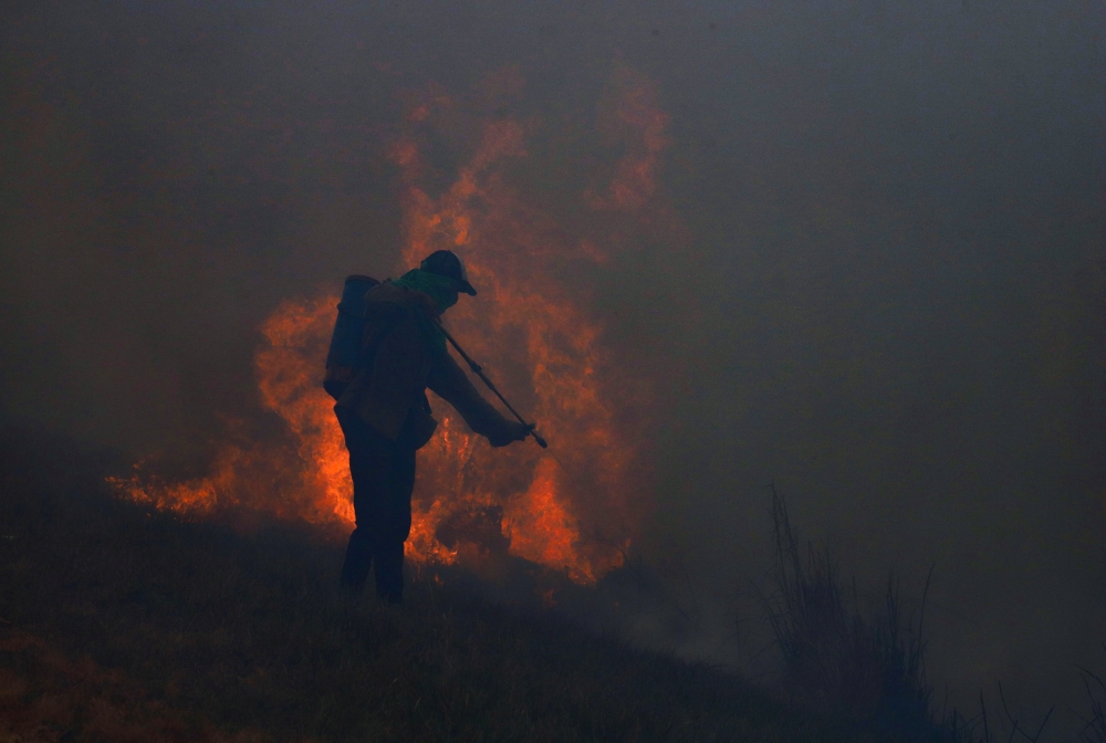 A man works to extinguish the fire that continues to consume trees and pastures in Ituzaingo, province of Corrientes, Argentina February 20, 2022. REUTERS/Matias Baglietto