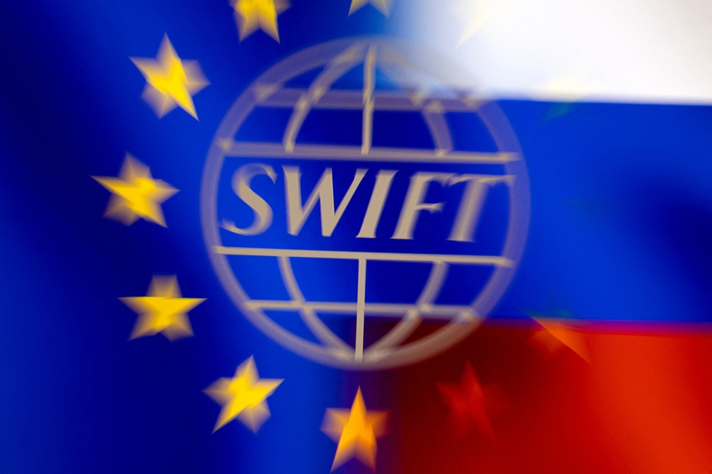 Swift logo is pictured with EU and Russian flags in this illustration picture taken February 26, 2022. Reuters/Dado Ruvic/Illustration