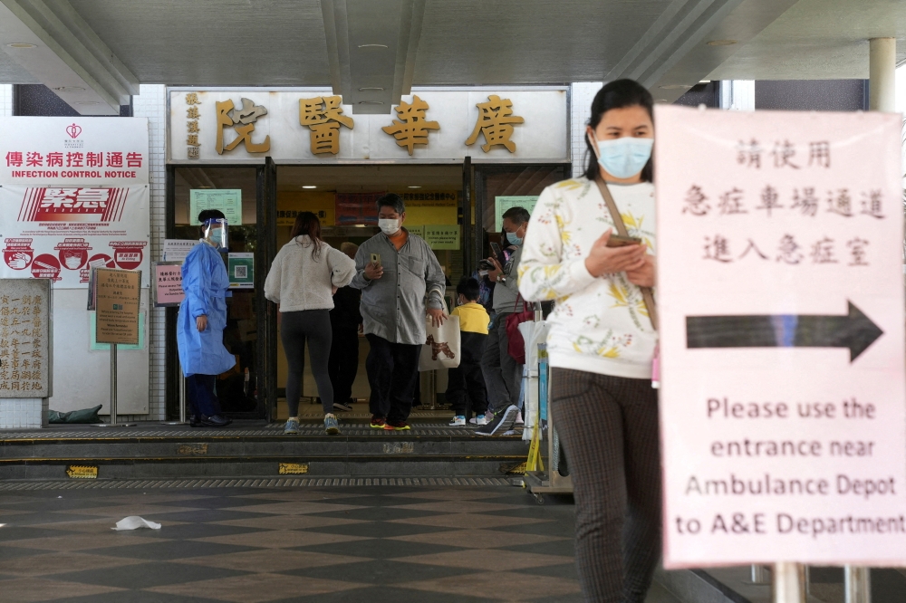 People walk at the entrance of a hospital, following the coronavirus disease (COVID-19) outbreak, in Hong Kong, China February 11, 2022. REUTERS/Lam Yik/File Photo