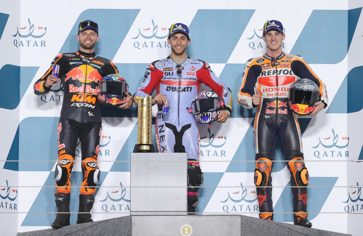MotoGP's Enea Bastianini celebrates on the podium with the trophy after winning the race with second place Red Bull KTM Factory Racing's Brad Binder and third place Repsol Honda Team's Pol Espargaro REUTERS/Ibraheem Al Omari
