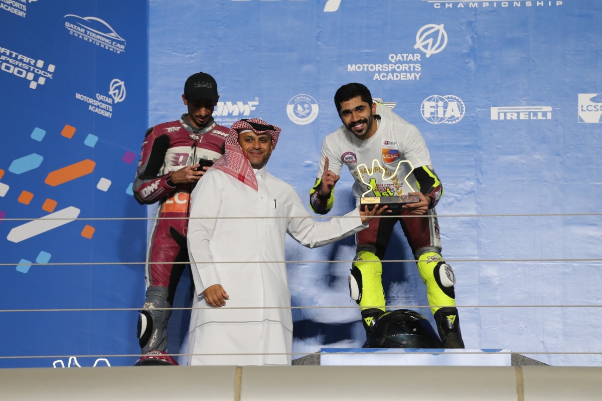Qatar Motor and Motorcycle Federation Executive Director Amro Al Hamad presents the trophy to QSTK 600 champion Abdulla Al Qubaisi after the sixth and final round at the Losail International Circuit, yesterday. 