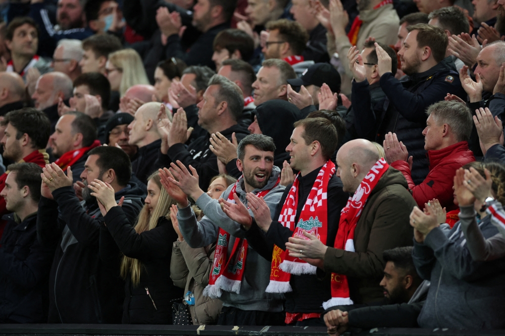 April 19, 2022 Liverpool fans applaud on the seventh minute for Manchester United 's Cristiano Ronaldo and his family REUTERS/Phil Noble