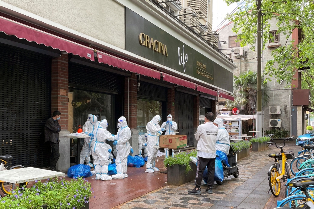 Workers dress up in protective suits amid the coronavirus disease (COVID-19) outbreak in Shanghai, China April 23, 2022. Reuters/Brenda Goh